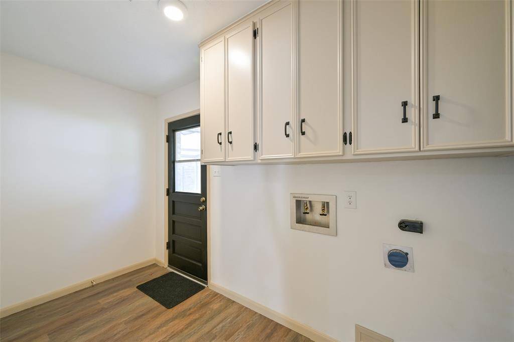 THE UTILITY ROOM IS SPACIOUS WITH ADDITIONAL CABINETS AND DOOR TO THE BACKYARD AND GARAGE.