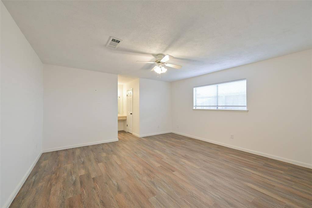 THE PRIMARY BEDROOM IS BOTH COMFORTABLE AND STYLISH WITH VINYL PLANK FLOORING.