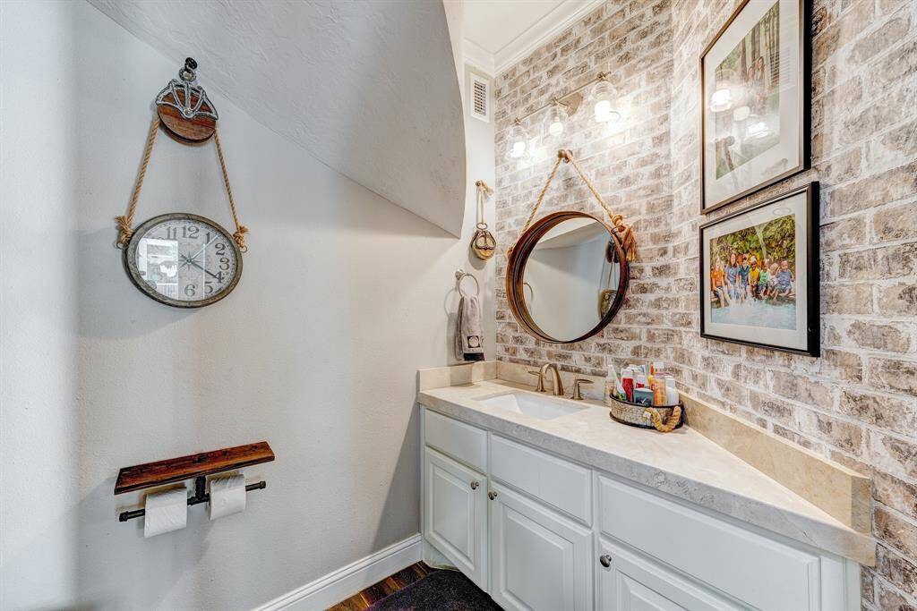 Half bath under sweeping stairs for guest use.