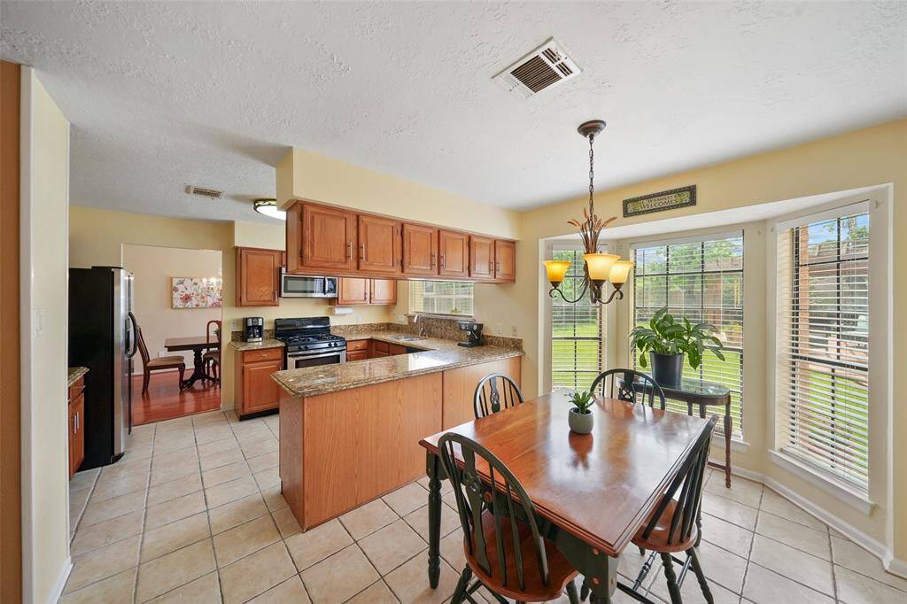 Bright kitchen and breakfast room with a seamless view into the elegant formal dining area.