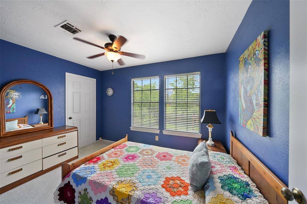Bright and cozy secondary bedroom with vibrant walls, ample natural light, and charming decor.
