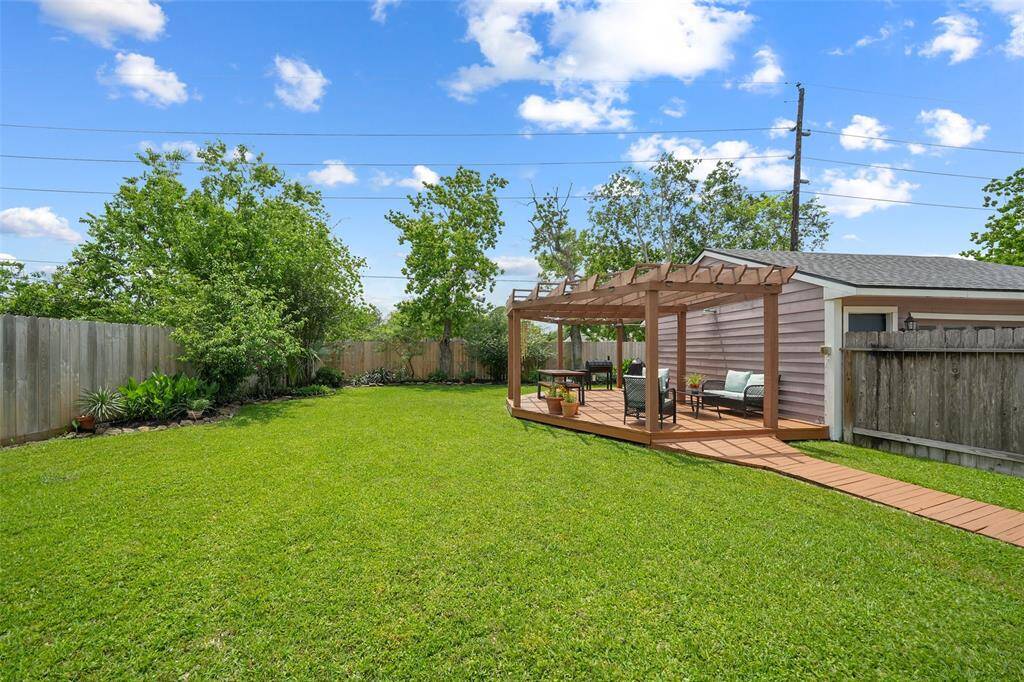 Charming backyard with a stylish pergola and deck, perfect for outdoor relaxation and entertaining.