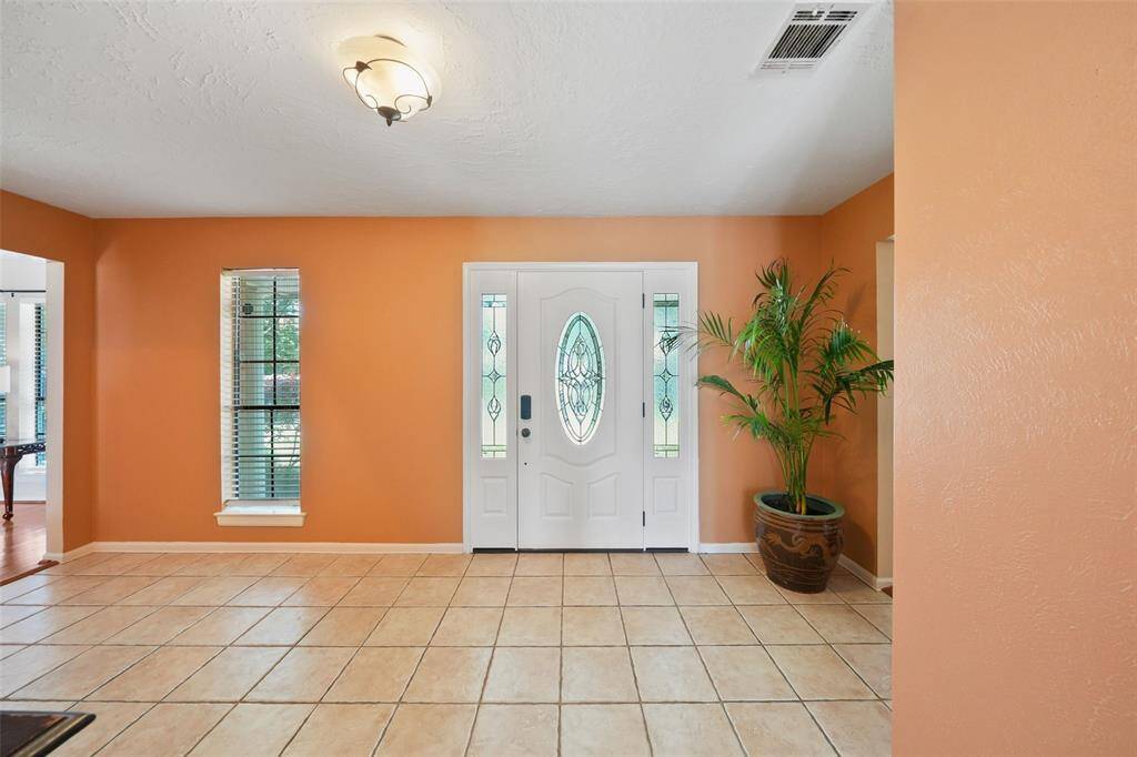 Welcome to a bright and airy foyer featuring large format tiles and abundant natural light.