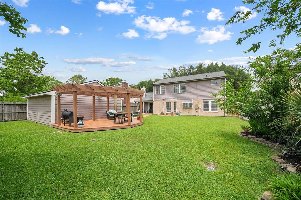 Spacious backyard with a charming pergola, perfect for outdoor gatherings and relaxation.