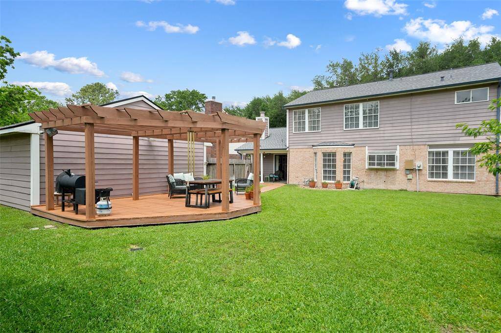 Spacious backyard with a charming pergola for outdoor dining and relaxation.