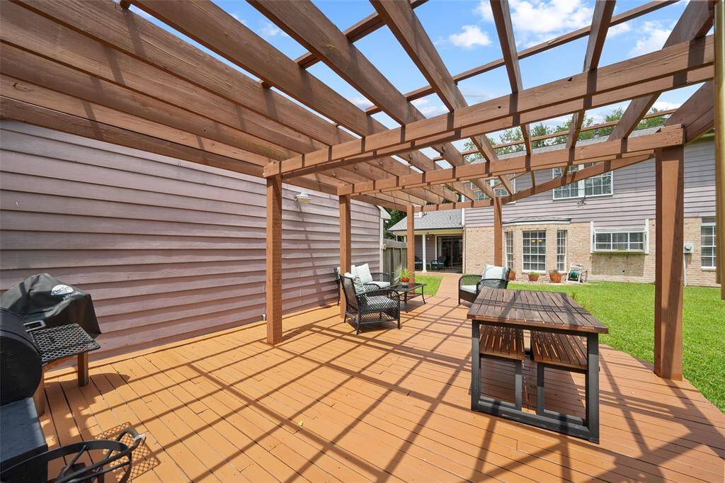 Expansive deck with a stylish pergola, perfect for outdoor gatherings.