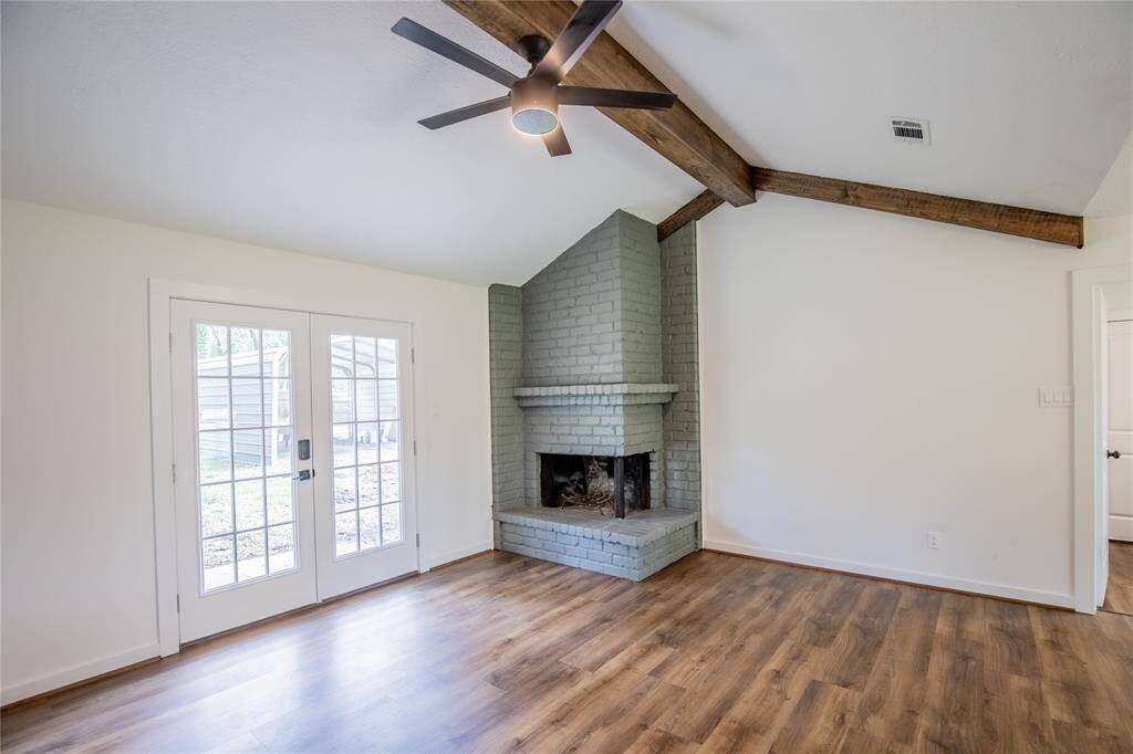 Towering ceilings with wood beam and unique fireplace.