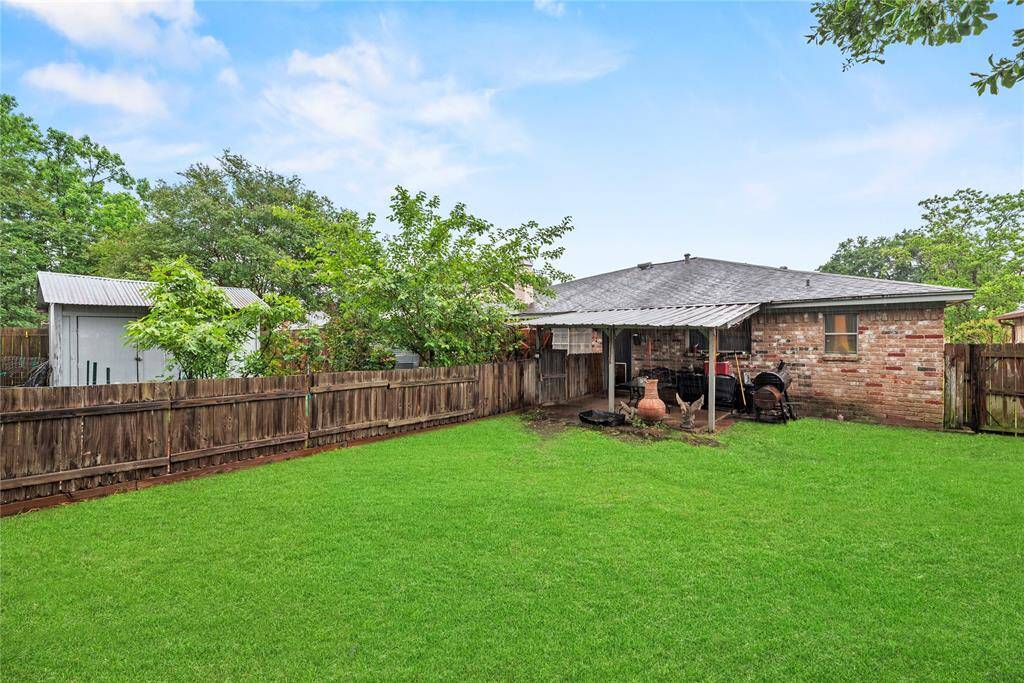 The spacious backyard is divided in half by a fence. There's ample space for gardening on one side while still having enough space for kids to play on the other side!