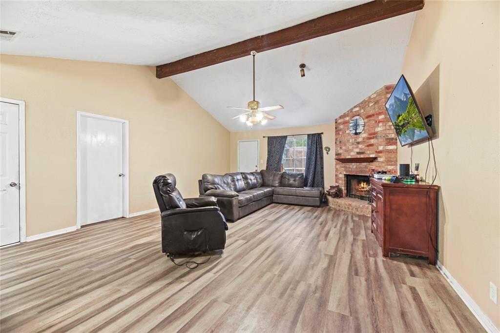 Large living room complete with fireplace and vaulted ceilings.