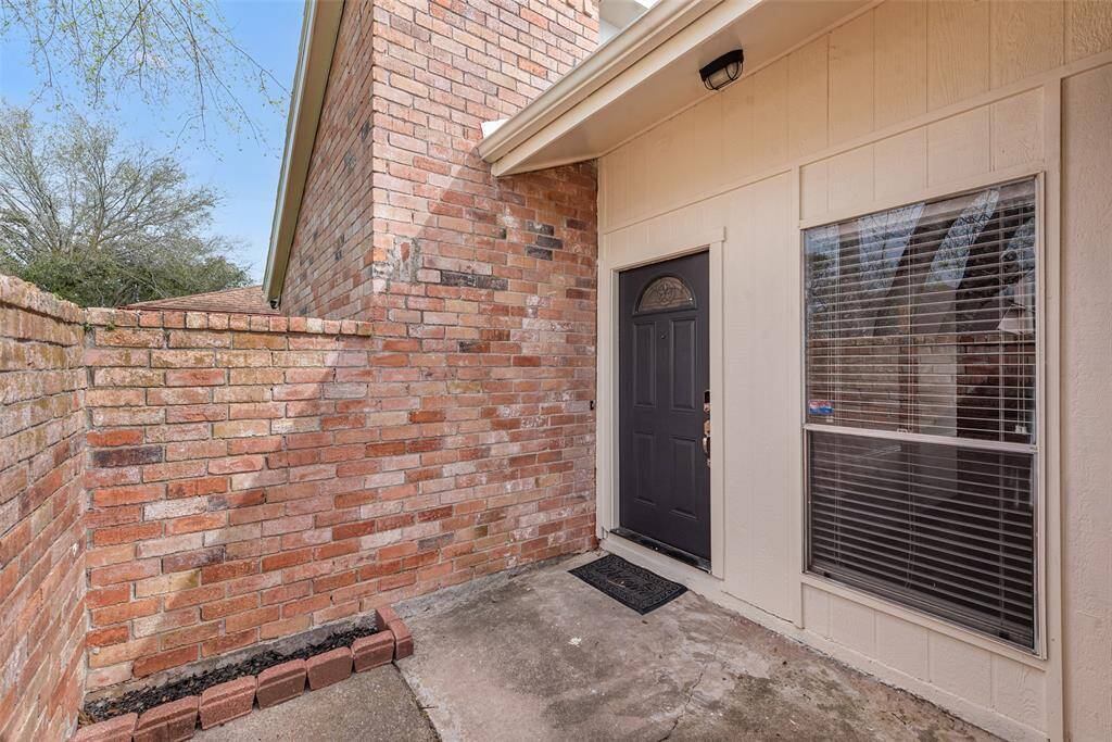 Warm welcoming courtyard leading to a solid wood door entry.