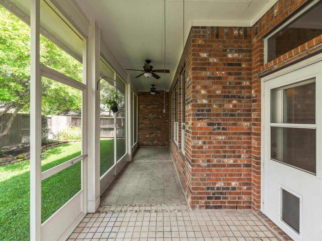 Screened-in back patio with tiled floor.