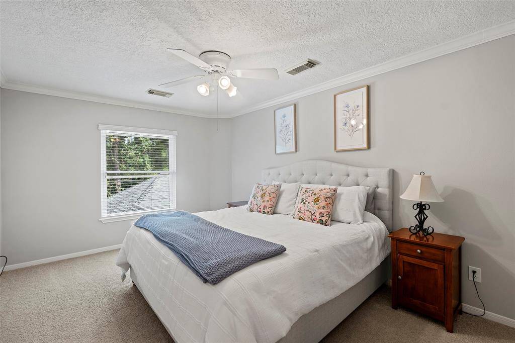 Upstairs boasts 3 secondary bedrooms each with their own character and charm. This one has crown molding, neutral tones and views of the trees!