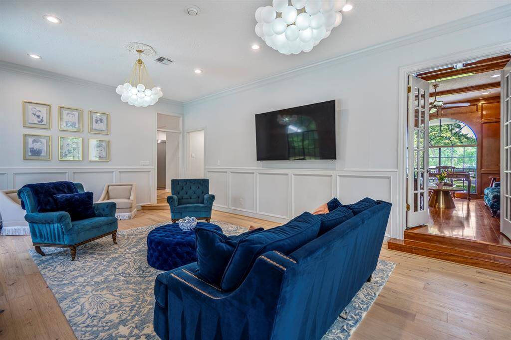 A large window with a garden view, soft lighting and tasteful decor create a warm, sophisticated ambiance in this living room.