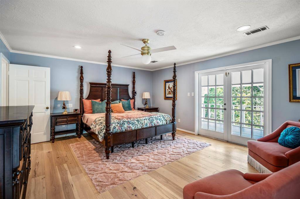 Spacious, elegant porch with ornate columns and French doors, offering a serene view of lush greenery. Ideal for relaxation and outdoor entertaining.  This is right off of the primary bedroom.  What a retreat!