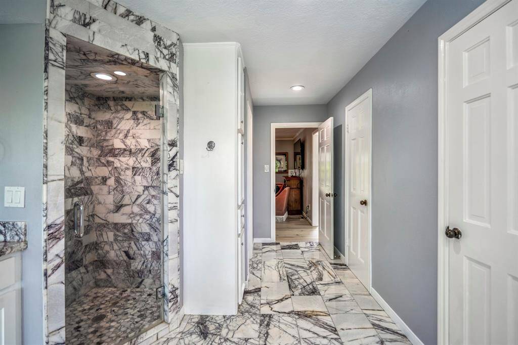 You will love getting ready in this bathroom with double sinks, a vanity area, marble countertops and a modern walk-in shower, surrounded by stylish marble tile. A large mirror and natural light enhance the airy feel.