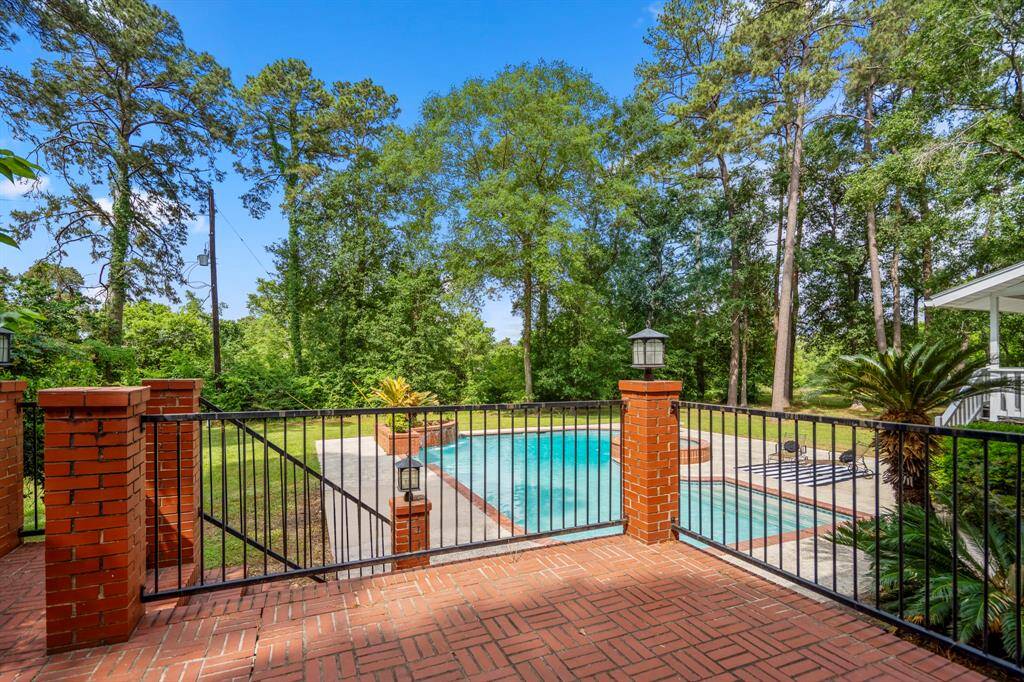 You will fall in love with this spacious backyard with a swimming pool surrounded by lush trees, providing a serene and private retreat. The area features a brick patio and decorative columns with lanterns, ideal for outdoor relaxation and entertaining.  Beyond the treeline is the Northgate Golf Course.