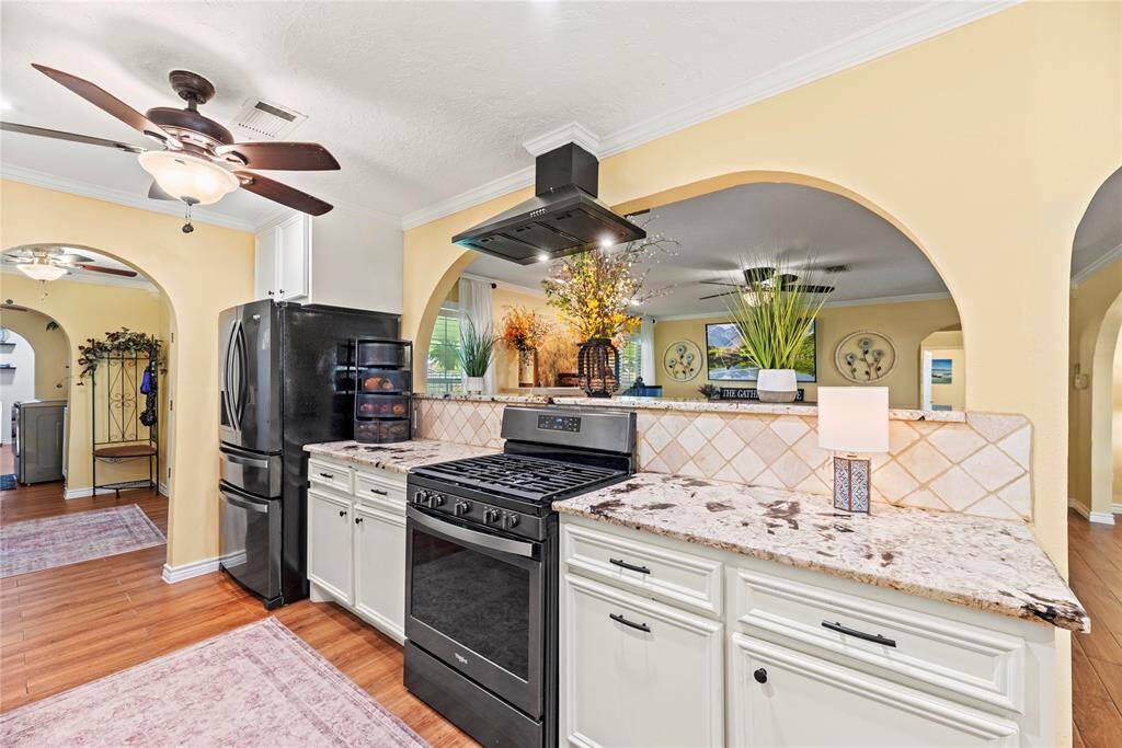 Bright kitchen with granite countertops, a gas range, and a breakfast bar overlooking the living room for a connected feel.