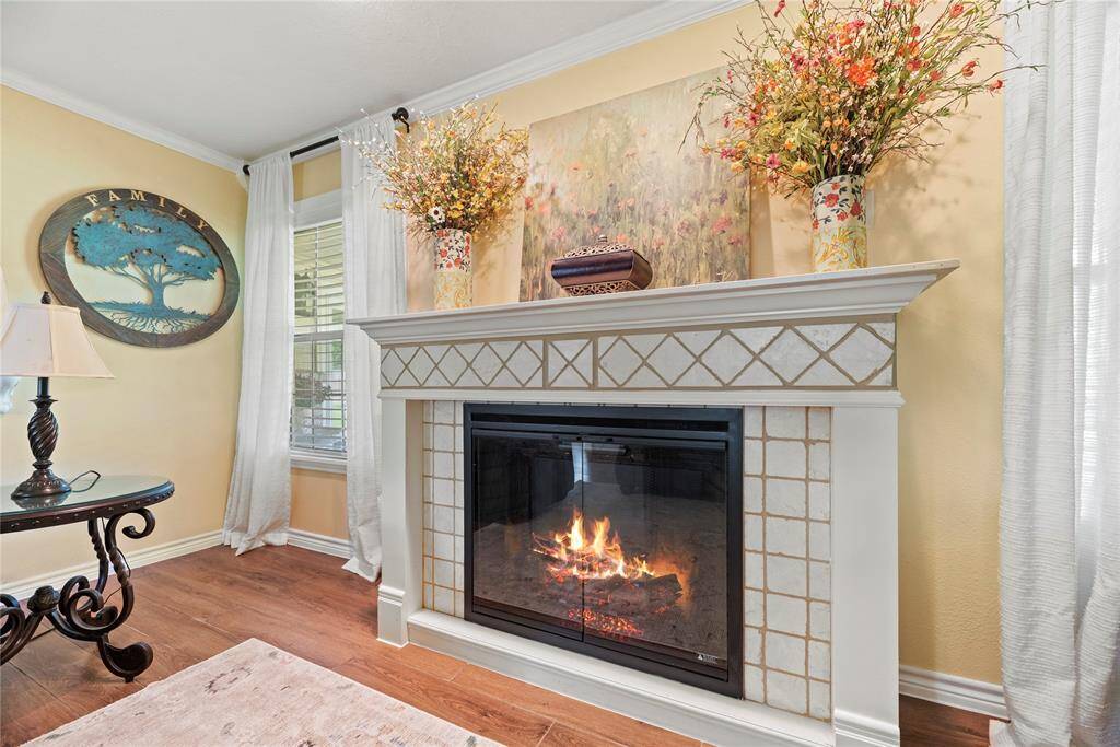 A beautiful centerpiece to the living area, the tile-accented fireplace adds warmth and charm, framed by elegant décor and light-filled windows.