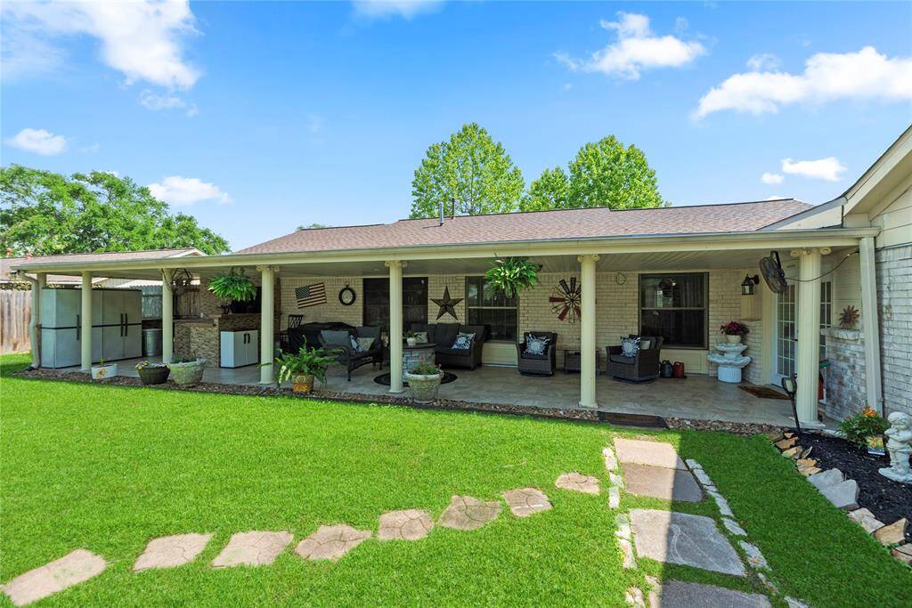 Expansive covered patio with tiled flooring and ceiling fans, offering the perfect shaded retreat for relaxing or entertaining.