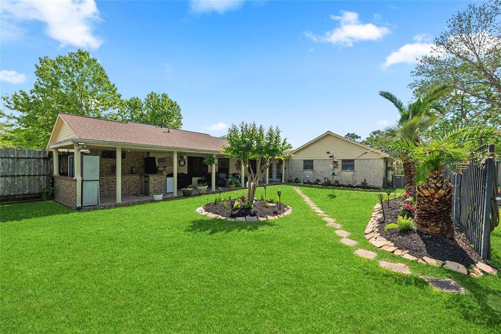 View of the backyard facing the home and covered patio, showing the home's generous outdoor entertaining space.