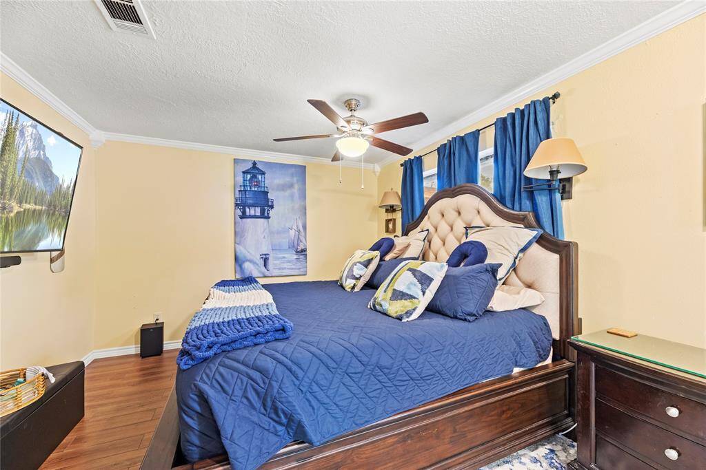 Retreat to a spacious secondary suite with elegant wall sconces and crown molding.