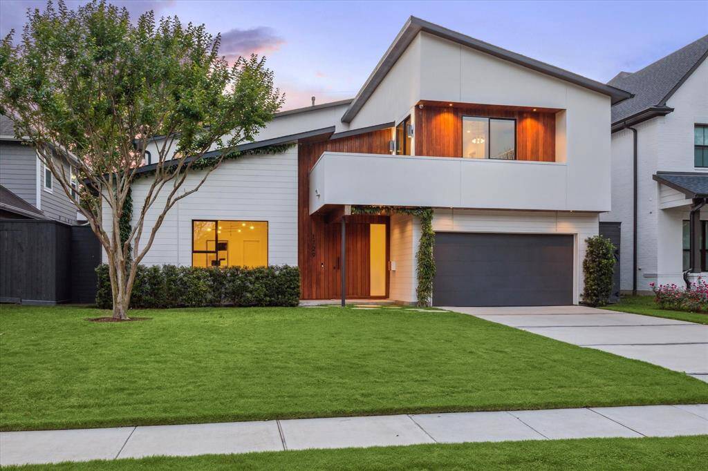 This stunning contemporary home showcases a bold and stylish exterior with a unique blend of natural wood accents, smooth light-colored siding, and sharp, angular rooflines that create striking architectural interest.