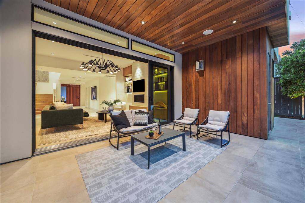 Warm wood accents on the ceiling and exterior walls create a sleek yet inviting atmosphere, perfect for relaxing or entertaining al fresco.
