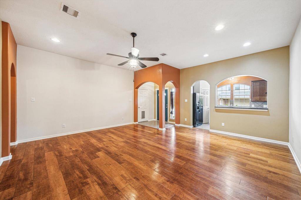 The family room features high ceiling, engineered wood flooring, recessed lighting and is accessed through an arched entry way from the front door.
