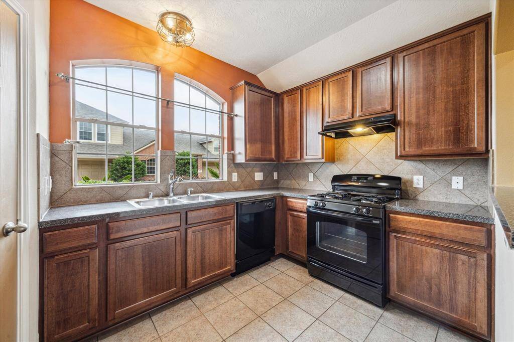 The kitchen is located a the front of the home. A large double arch topped window allows lots of natural light. Features include 42" cabinets, laminate countertops with tile backsplash, S/S sink, black finish dishwasher & gas range, ceramic tile floor and walk-in pantry.