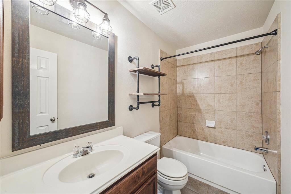 Full bath 2 has solid surface vanity top, a tub/shower combo with ceramic tile surround and ceramic tile floor.
