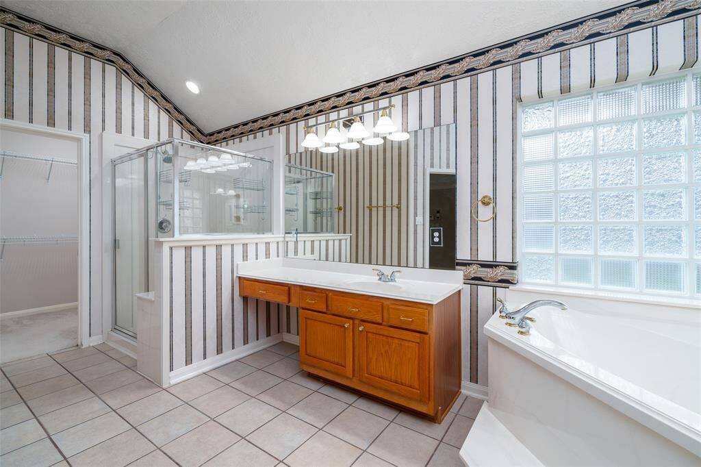 Primary bathroom offers a large walk-in shower and a jetted soaker tub and double vanities