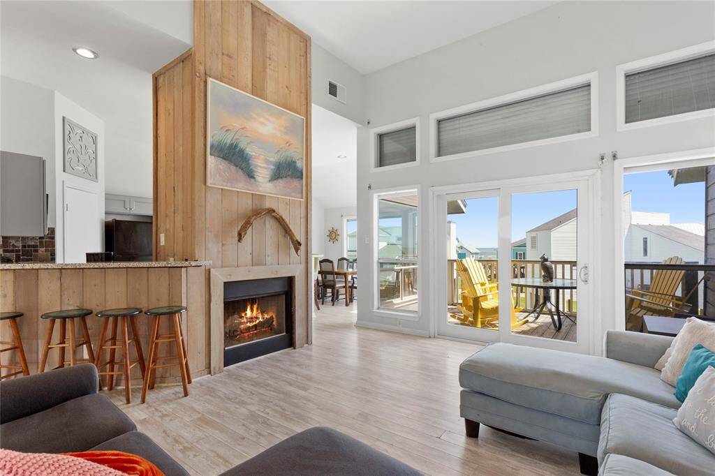 Living area with cozy fireplace, wall of windows not only offer gulf views, they also have hurricane shutters!