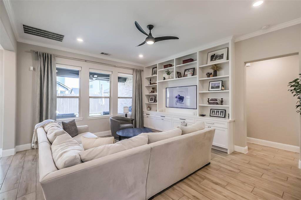 CUSTOM BUILT SHELVES and cabinetry elevate the living room and provide lots of storage.