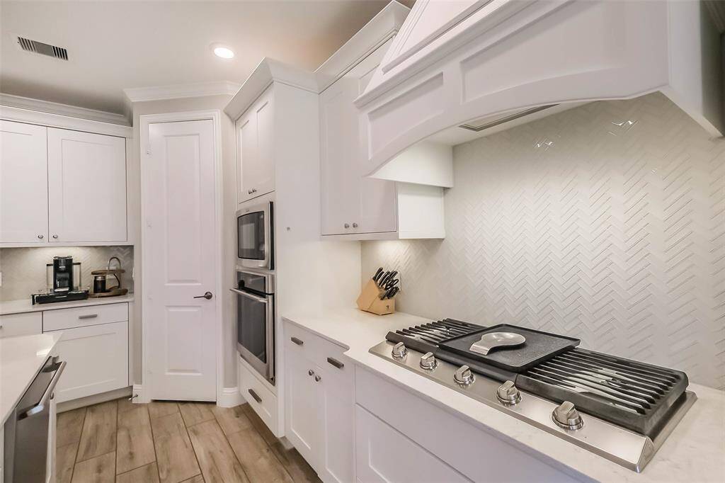 The 5 burner gas cooktop and herringbone tile backsplash is classic, stunning and looks like new!