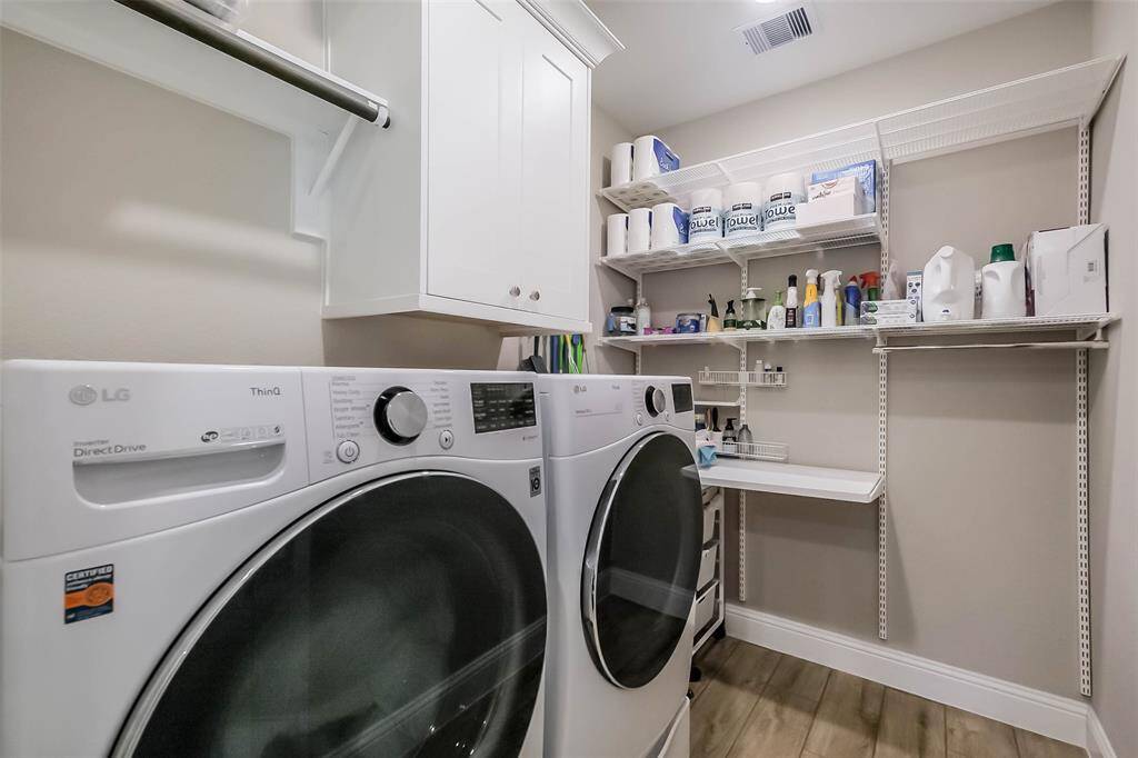 The main utility room features lots of storage space, cabinets and a folding table.