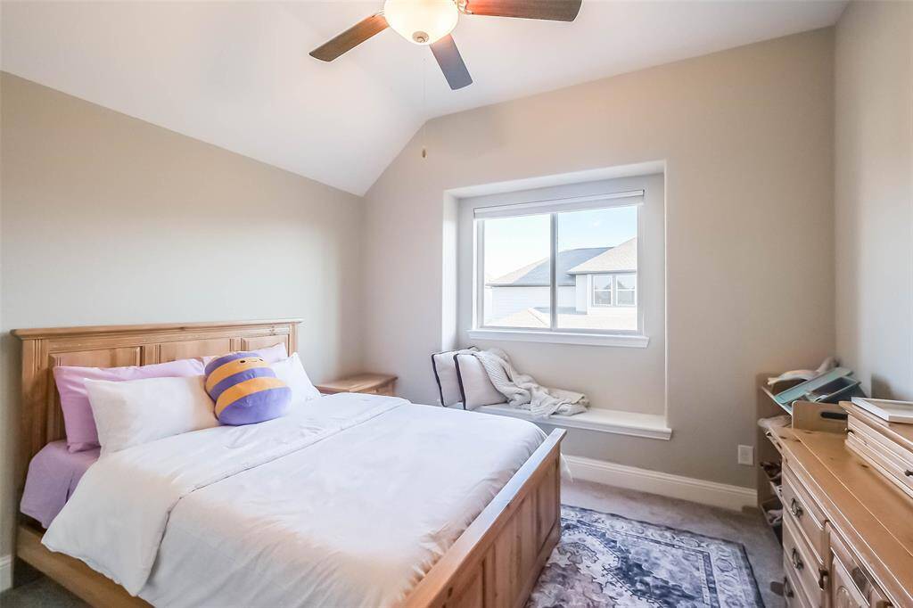 Upstairs secondary bedroom with ceiling fan and little window seat.