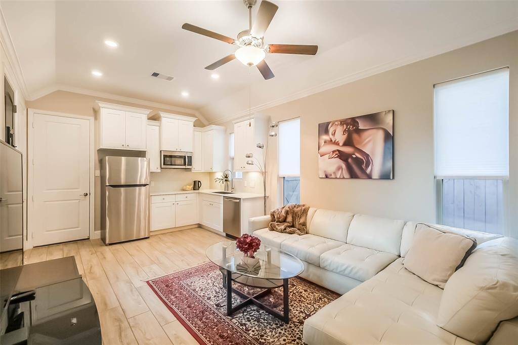 The spacious and bright guest suite features a full kitchen with STANDARD SIZE STAINLESS STEEL APPLIANCES (all included!), white painted cabinetry, window treatments, crown molding and the same wood-look tile flooring as the main residence.