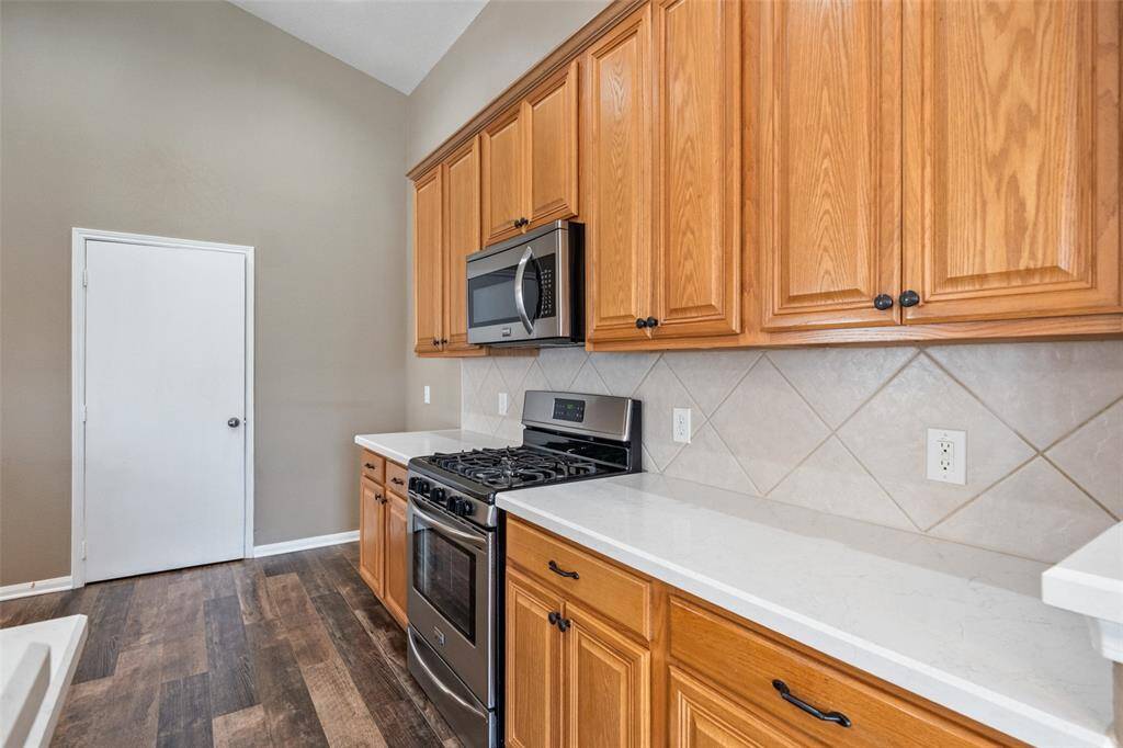 Ditch the takeout and enjoy home-cooked meals in this well-equipped kitchen, complete with sleek Quartz countertops, stainless steel appliances including a gas range and built-in microwave, and plenty of cabinetry for all your cooking essentials.