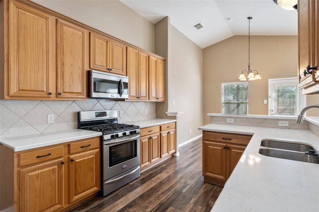 Designed for both everyday living and entertaining, this kitchen shines with stainless steel appliances, sleek Quartz countertops, tile backsplash, and abundant cabinetry. A spacious pantry offers even more storage, while the wraparound bar and open layout create an easy flow into the family and dining areas keeping everyone connected from prep to plate.