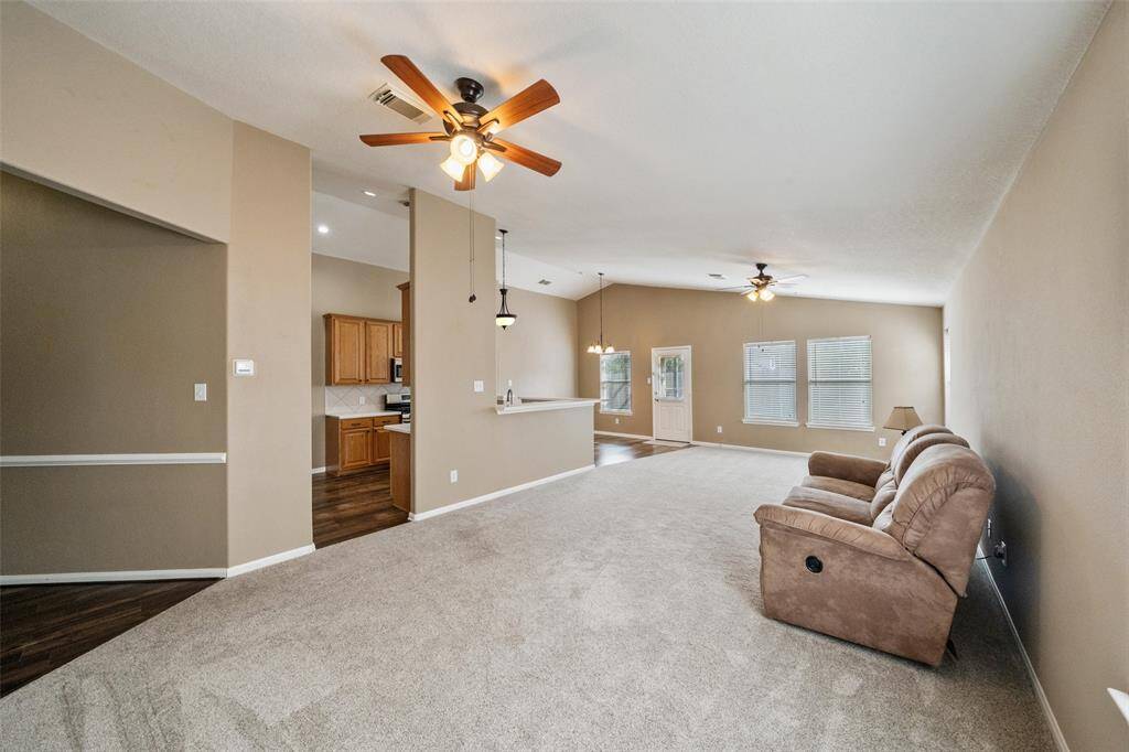 This open family room offers a spacious layout with a soaring ceiling, neutral tones, and abundant natural light making it perfect for everyday living and effortless entertaining.