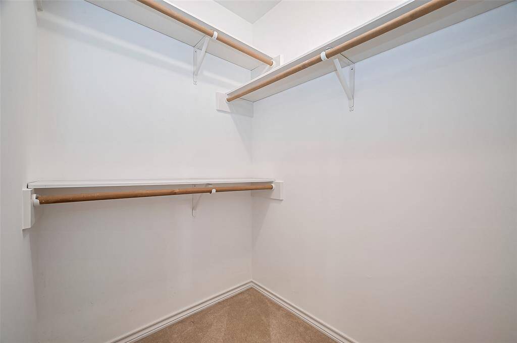 The ensuite bath features two lighted walk-in closets, each with multiple rods for hanging and organizing clothes. These generously sized closets offer plenty of space to keep your wardrobe neatly arranged and easily accessible.