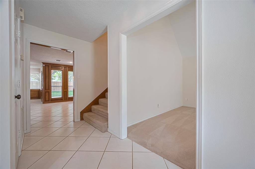 Off the foyer, between the front study and the family room, a carpeted staircase leads to the second floor. The carpet provides solid traction underfoot and continues upstairs, helping to muffle sound between floors—ideal for keeping the first floor quiet and peaceful.