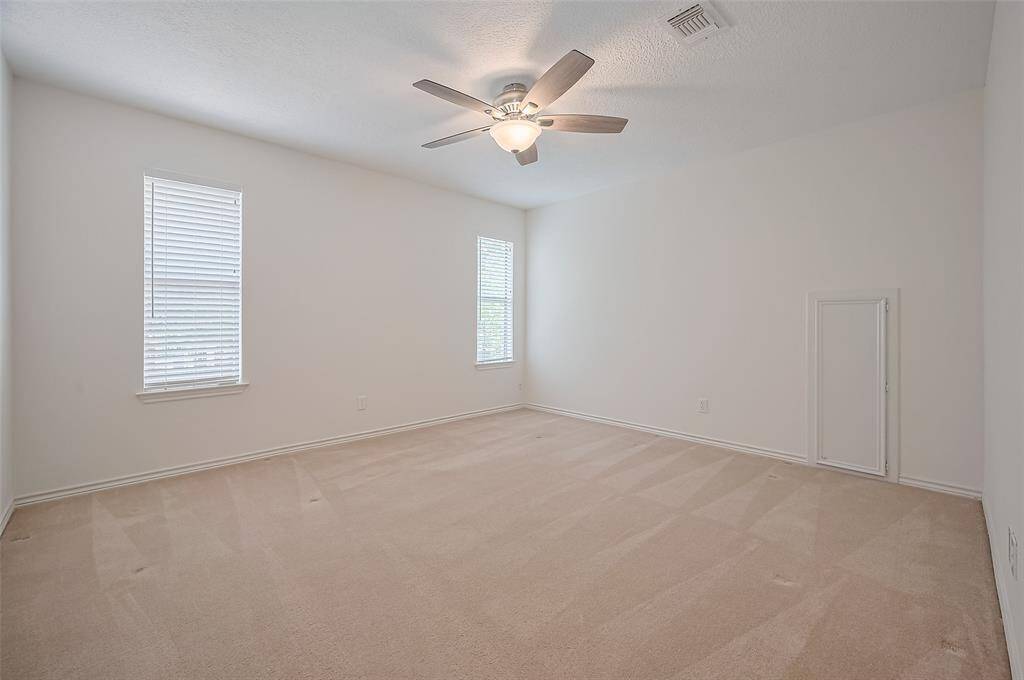 Upstairs you'll find three generously sized secondary bedrooms, each with its own lighted walk-in closet. Bedroom #2 (13.8 x 11.9) features plush carpeting, a ceiling fan, and two windows overlooking the backyard—filling the room with warm natural light. Ample wall space allows for flexible furniture arrangements, making it a cozy and functional retreat for guests, kids, or a creative home workspace.