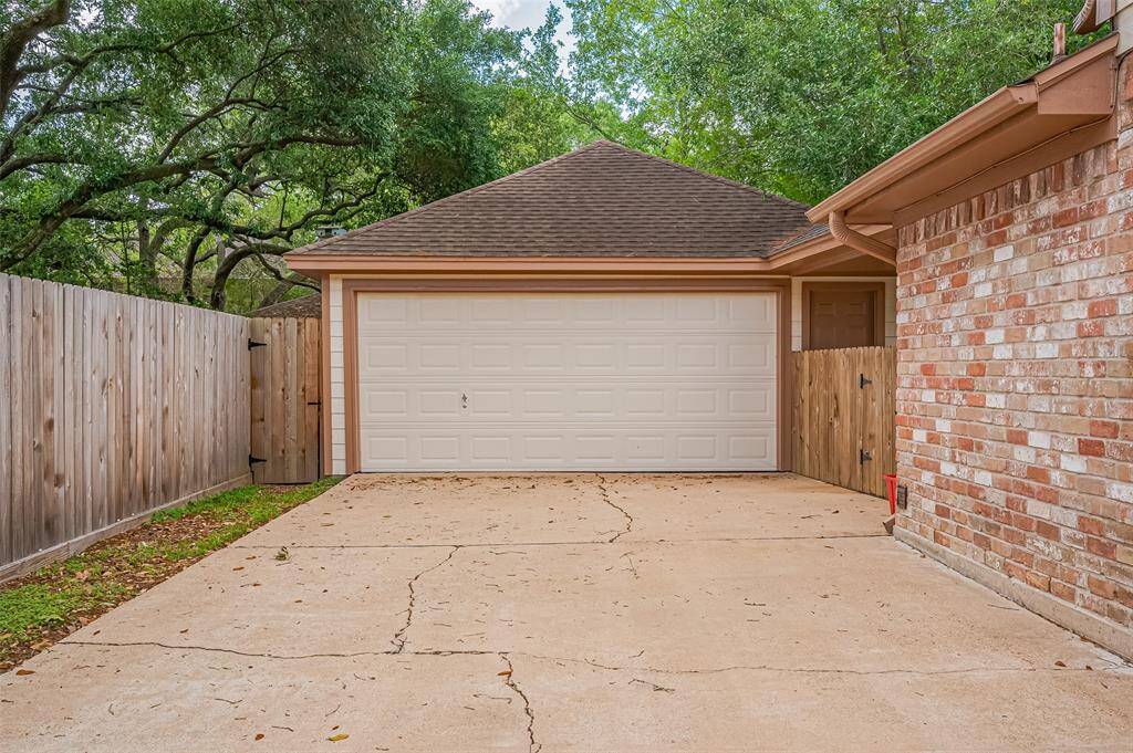 The back of the home showcases its beautiful blend of brick and Hardie board siding, creating a striking and durable exterior. The home is equipped with gutters to efficiently direct water away from the foundation. The backyard is truly a tranquil retreat, highlighted by a gorgeous shade tree that provides a canopy, offering shade and creating a peaceful outdoor space for relaxation or entertaining.
