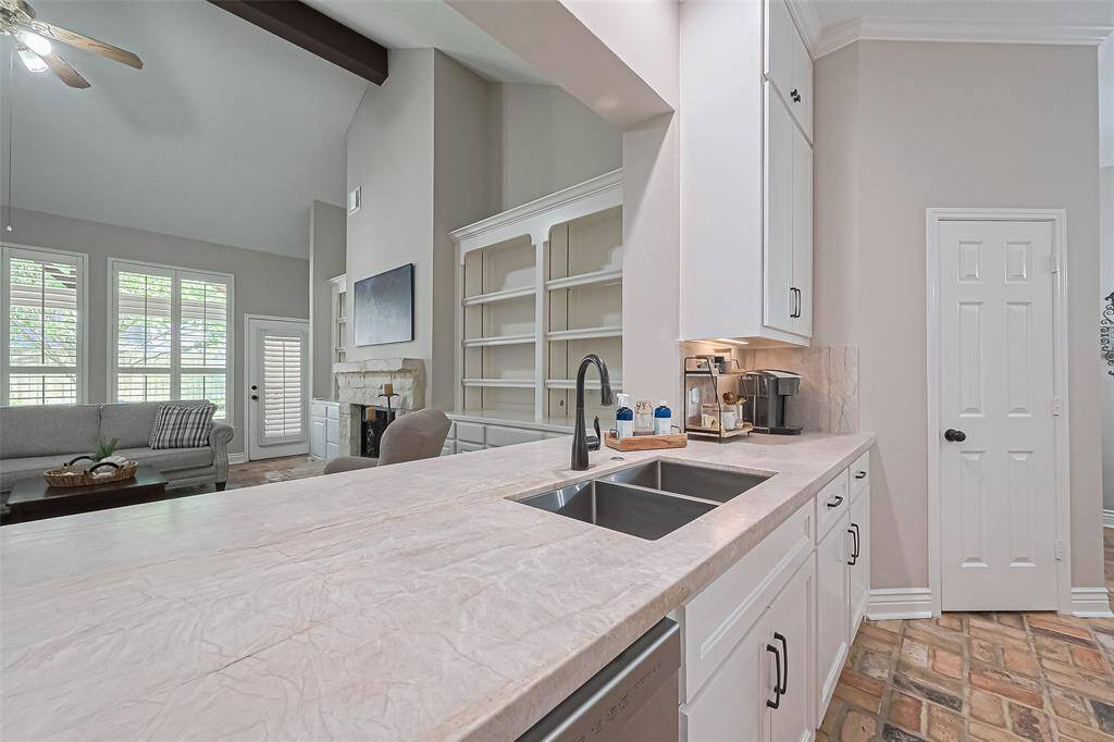 BEAUTIFULLY remodeled kitchen with classy quartzite countertops & backsplash, custom cabinets & walk-in pantry for plenty of storage, and open to the living room