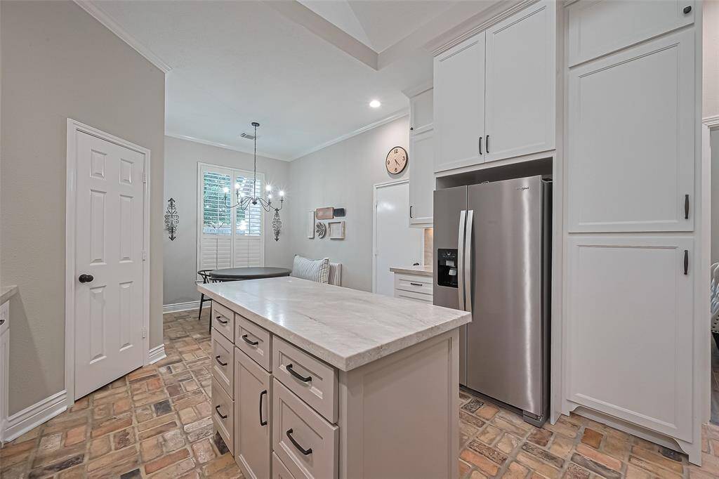 BEAUTIFULLY remodeled kitchen with classy quartzite countertops & backsplash, custom cabinets & walk-in pantry for plenty of storage, and open to the living room