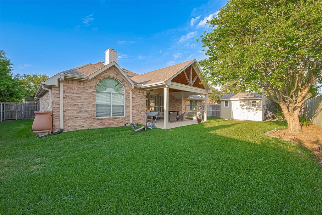 You will LOVE your back yard with its covered back porch, storage shed, and shade tree.
