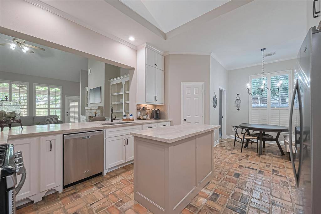 BEAUTIFULLY remodeled kitchen with classy quartzite countertops & backsplash, custom cabinets & walk-in pantry for plenty of storage, and open to the living room