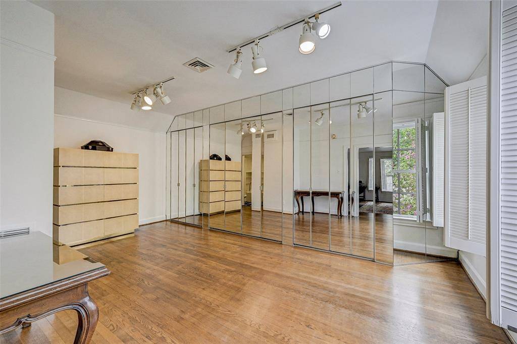 Sitting room or office with a wall of closets adjacent to primary bedroom
