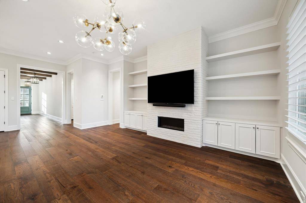 A gas brick fireplace with mounted TV creates a focal point for this spacious living room.